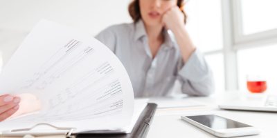 Zamestnávateľka prechádza neplatné dokumenty a zamýšľa sa nad chýbajúcimi údajmi