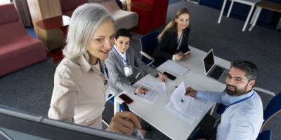 Lektorka vedie odborné kurzy pri tabuli pre skupinu zamestnancov